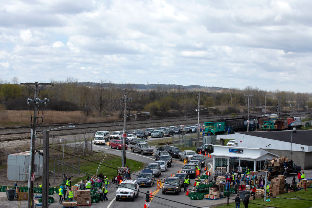 SYRACUSE, NY – MAY 12: Cars line up as volunteers participate in a drive-through food bank at the New York State Fairgrounds on May 12, 2020. (Photo by Stefani Reynolds/Getty Images)
