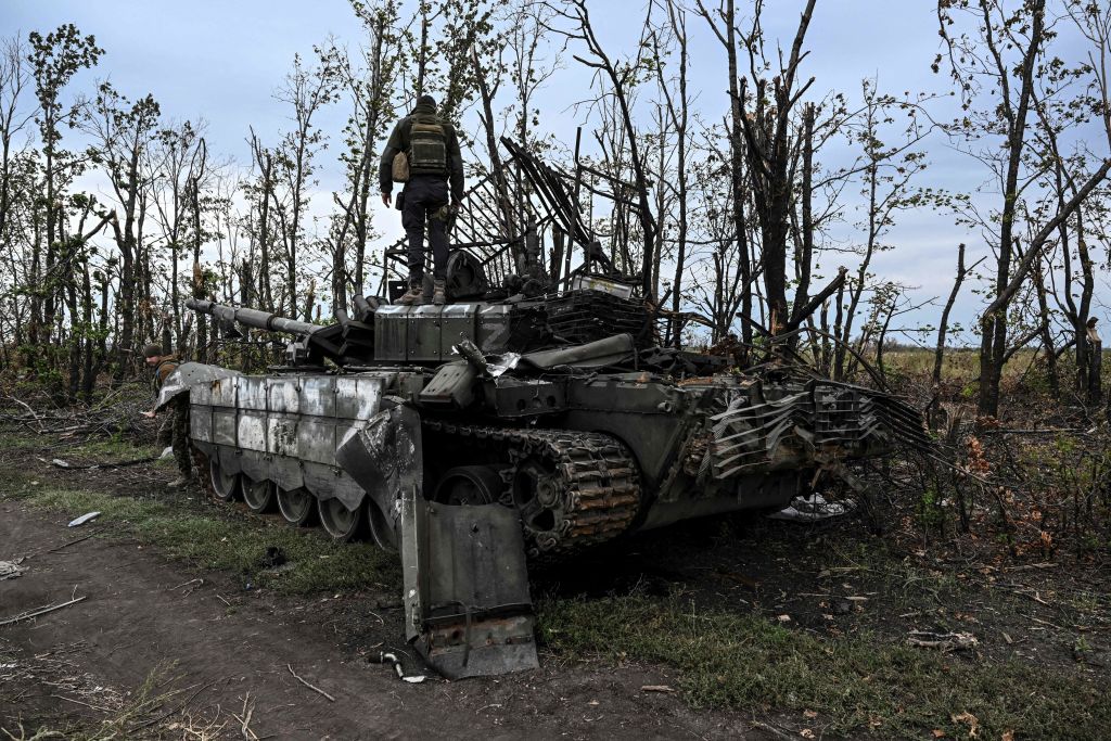 This photograph taken on September 11, 2022, shows a Ukranian soldier standing atop an abandoned Russian tank near a village on the outskirts of Izyum, Kharkiv Region, eastern Ukraine, amid the Russian invasion of Ukraine. (Photo by Juan BARRETO / AFP) (Photo by JUAN BARRETO/AFP via Getty Images)