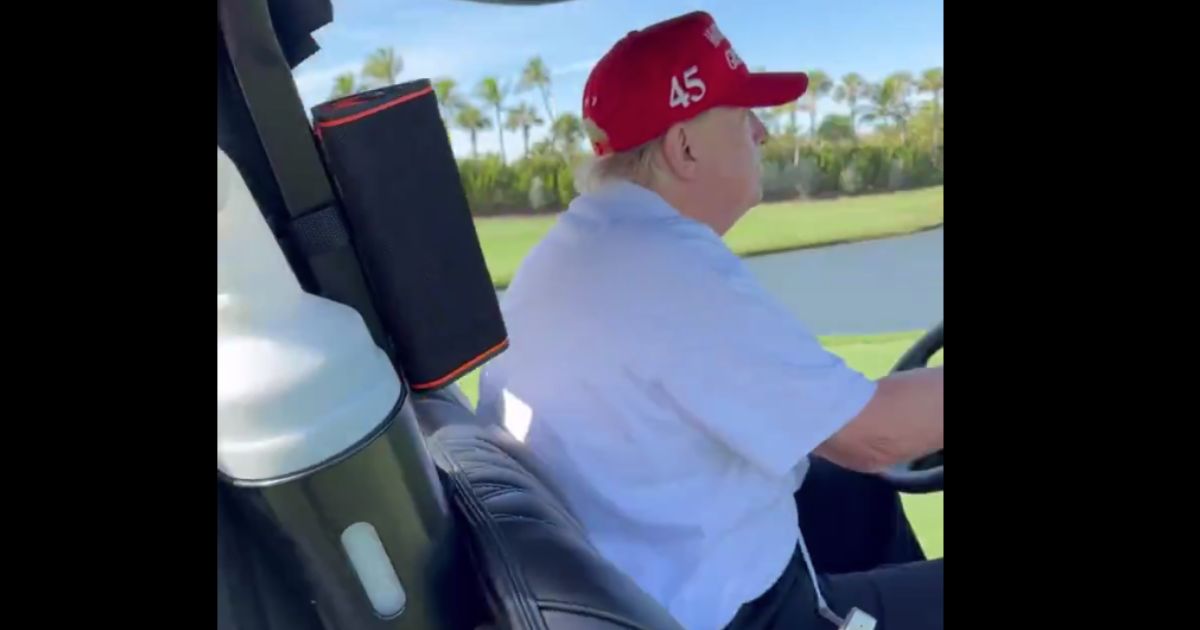 Trump Jams Out to Music While Driving Golf Cart ‘#47’ – Asks Bystander, ‘You Ever Hear This One?’