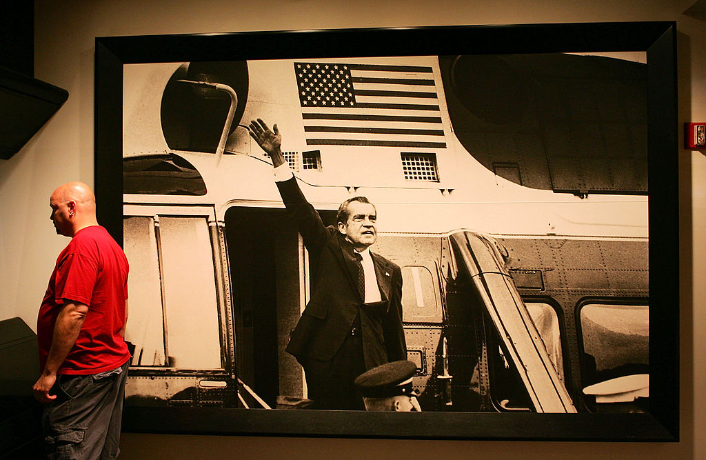 YORBA LINDA, CA – MAY 31: A visitor stands next to an image of President Richard Nixon waving near the Watergate Era portion of the Nixon museum at the Richard Nixon Library & Birthplace on May 31, 2005 in Yorba Linda, California. A Vanity Fair magazine article reports that a retired FBI official, Mark Felt, was the “Deep Throat” source who spoke to two Washington Post reporters about the Watergate scandal that forced former president Richard Nixon to resign in 1974. (Photo by David McNew/Getty Images)