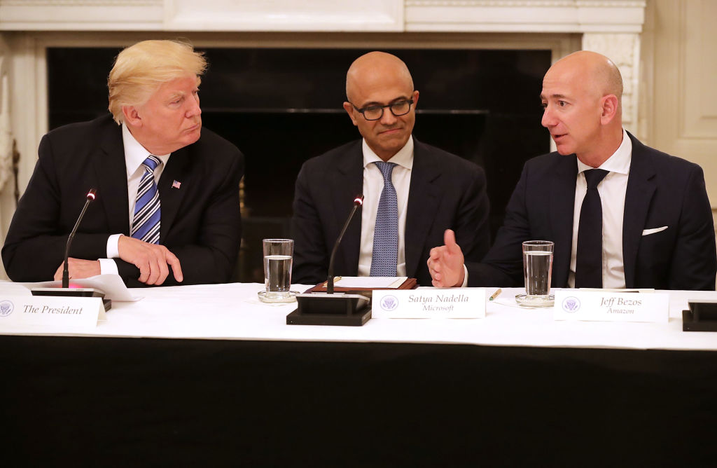 WASHINGTON, DC – JUNE 19: (L-R) U.S. President Donald Trump, Microsoft CEO Stya Nadella and Amazon CEO Jeff Bezos attend a meeting of the American Technology Council in the State Dining Room of the White House June 19, 2017 in Washington, DC. According to the White House, the council’s goal is “to explore how to transform and modernize government information technology.” (Photo by Chip Somodevilla/Getty Images)